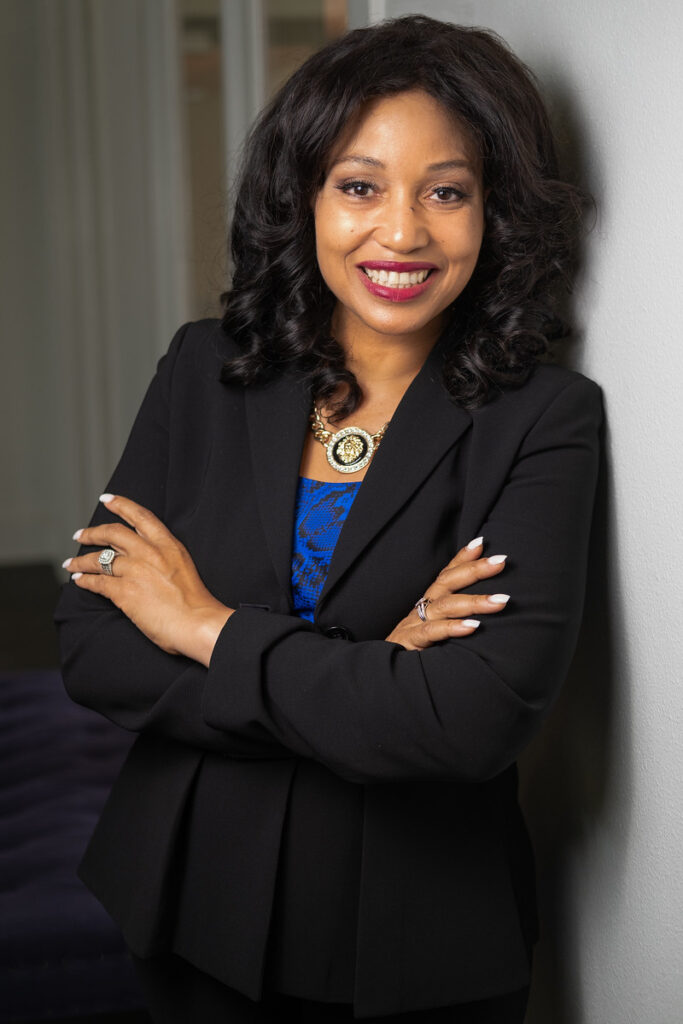 Smiling businesswoman in a black blazer with arms crossed, professional headshot in Seattle