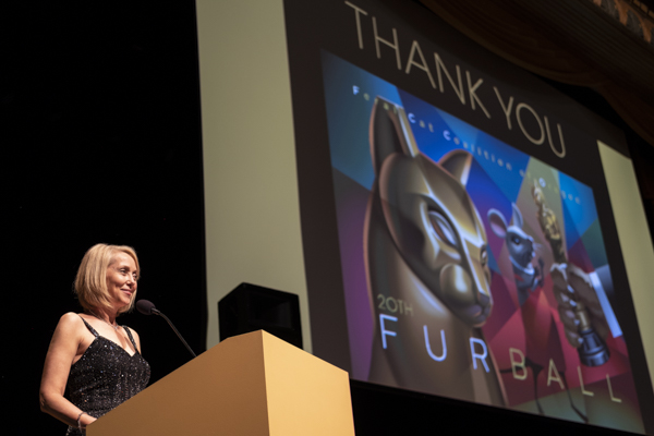 Speaker at a podium thanking guests at the Feral Cat Coalition of Oregon 20th Furball gala